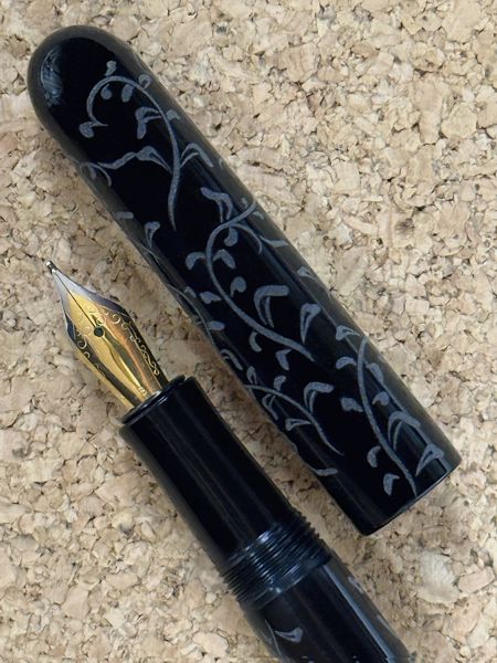 Loa Jr Clipless in Black Acrylic with Flower Scroll Engraving (close-up)